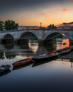 Bridge over river against sky during sunset