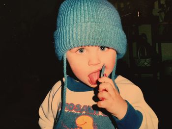 Close-up portrait of boy licking toy