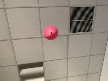 Close-up of pink balloons against wall in building