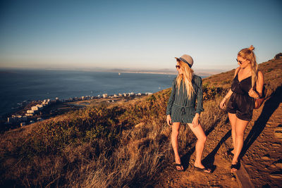 People standing on beach against clear sky