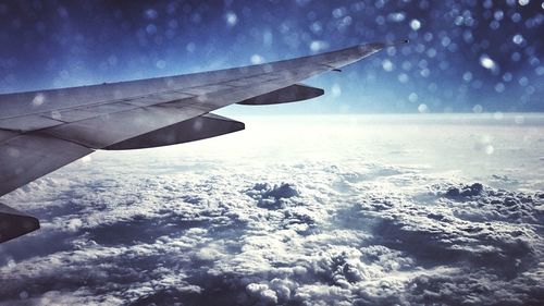 Cropped image of airplane flying over cloudscape