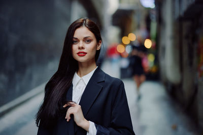 Portrait of young businesswoman standing outdoors
