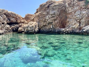 Rock formation in sea against sky