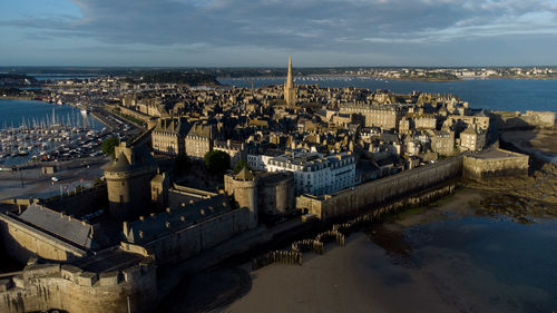 High angle view of townscape by sea against sky