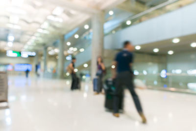 Defocused image of people walking on illuminated railroad station