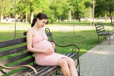 Pregnant woman sitting in park