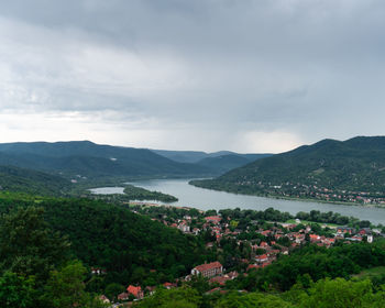 Scenic view of townscape by mountains against sky