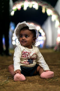 Portrait of cute baby girl sitting outdoors