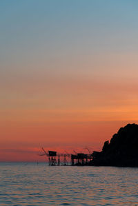 Scenic view of sea against sky at sunset. scenic view of fishery against sky at sunset 