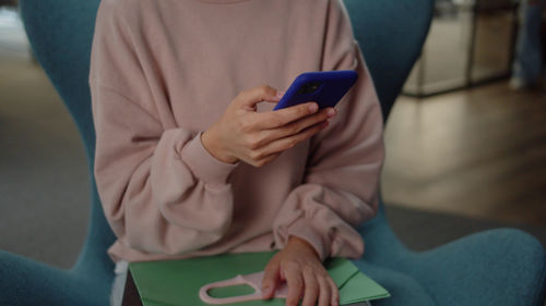 Midsection of woman using mobile phone