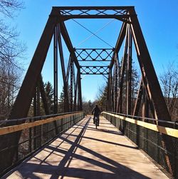 Rear view of man walking on footbridge