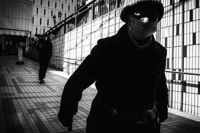 Man with umbrella walking on footpath