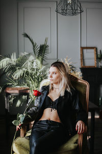 Thoughtful young woman wearing black jacket at home