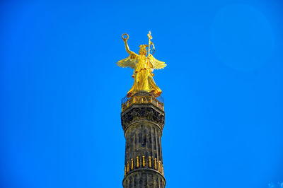 Low angle view of statue of liberty against blue sky