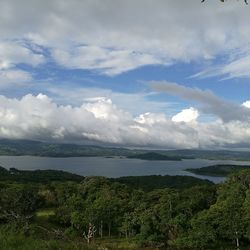 Scenic shot of calm countryside lake against cloudy sky