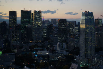 Illuminated cityscape against sky at night