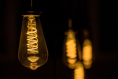 Close-up of light bulb hanging on glass