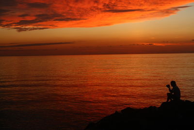 Silhouette of people on beach at sunset