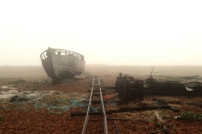 Abandoned boat on landscape against clear sky