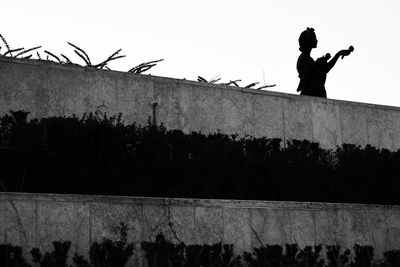 Silhouette man standing against wall