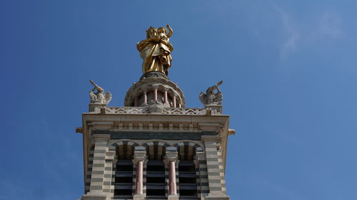 Low angle view of statue against clear blue sky