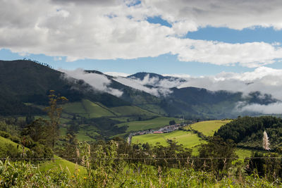 Scenic view of field and mountains against sky