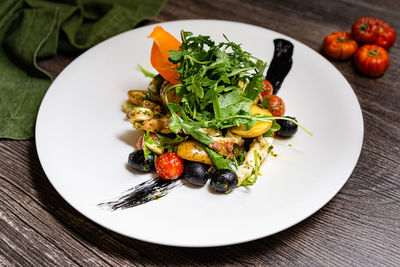 Italian salad with octopus in ligurian style. arugula, black olives, cherry tomatoes, octopus.