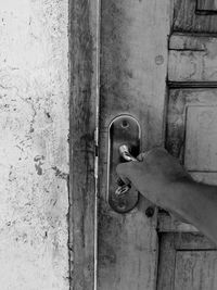 Human hand holding metal door
