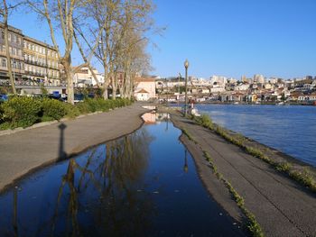 River by buildings in city against sky