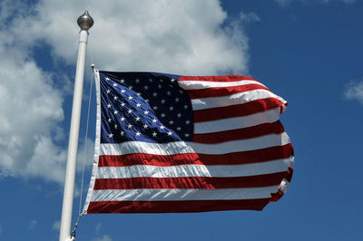 Low angle view of flag against blue sky