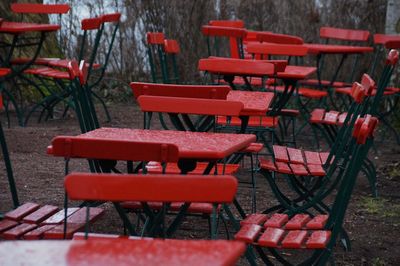 Wet red chairs and tables at cafe