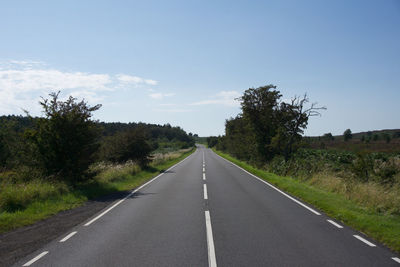 Road amidst trees against sky