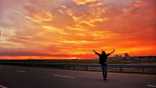 Silhouette of man against cloudy sky at sunset