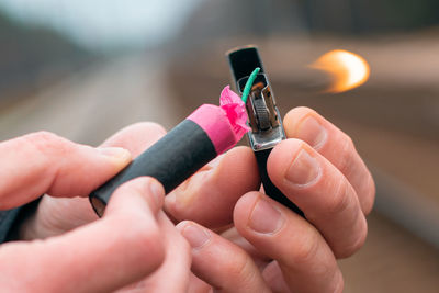 Close-up of hand holding lighter and bomb