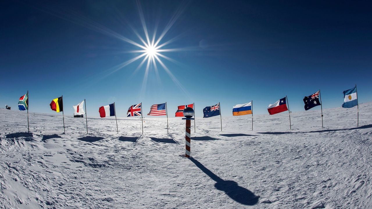 sunlight, flag, sun, clear sky, blue, low angle view, sunny, hanging, sky, national flag, sunbeam, identity, lens flare, text, day, pole, multi colored, patriotism, outdoors, in a row