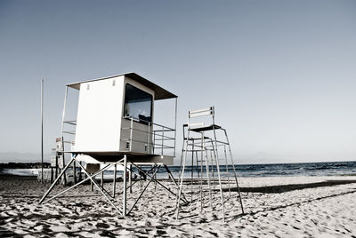 Low angle view of lifeguard hut and lookout tower on beach
