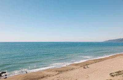 Scenic view of beach against clear blue sky