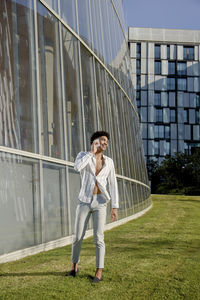 Full length of young man standing against building