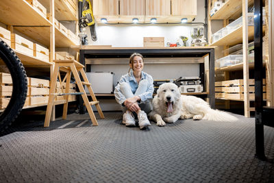 Portrait of woman with dog sitting outdoors