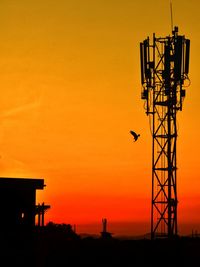 Silhouette of electricity pylon against sky during sunset