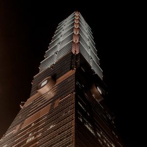 Low angle view of illuminated building against sky at night