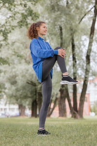 European woman does sports in a park or a public place. warm-up and jogging in the fresh air