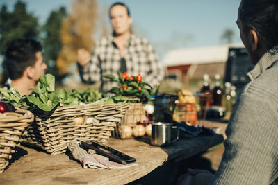 Farmers having discussion with mobile phone and organic vegetables on table