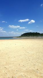 Scenic view of beach against blue sky