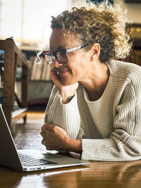 Young woman using laptop while sitting at home