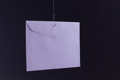 Close-up of paper hanging against black background