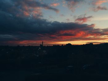 Silhouette landscape against cloudy sky during sunset