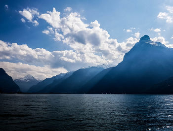 Scenic view of sea and mountains against sky