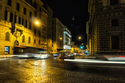 Illuminated city road against at night