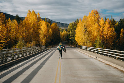 Man riding bicycle on road during autumn